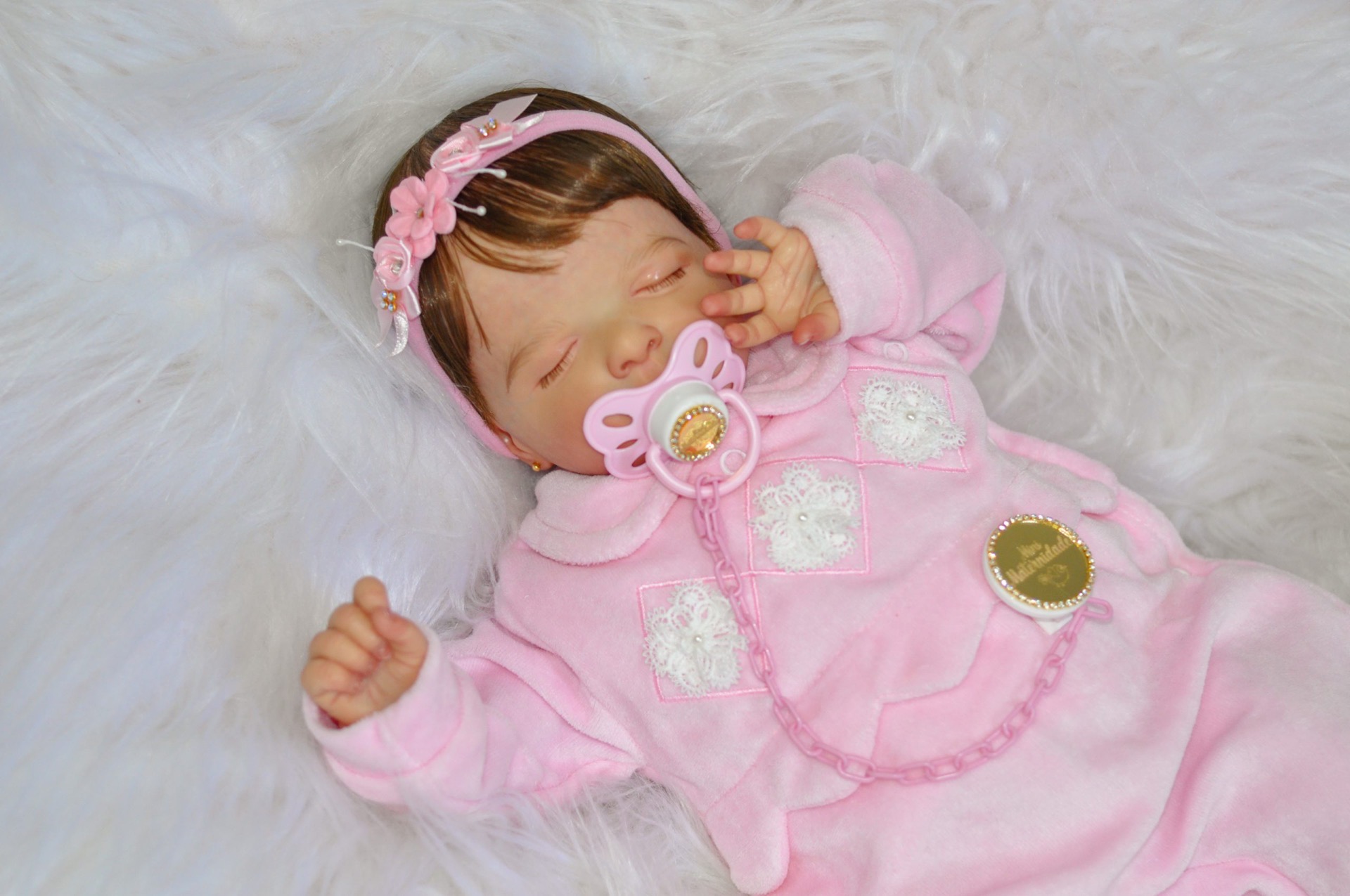 Bebê reborn realista da Mini Maternidade, vestindo macacão rosa